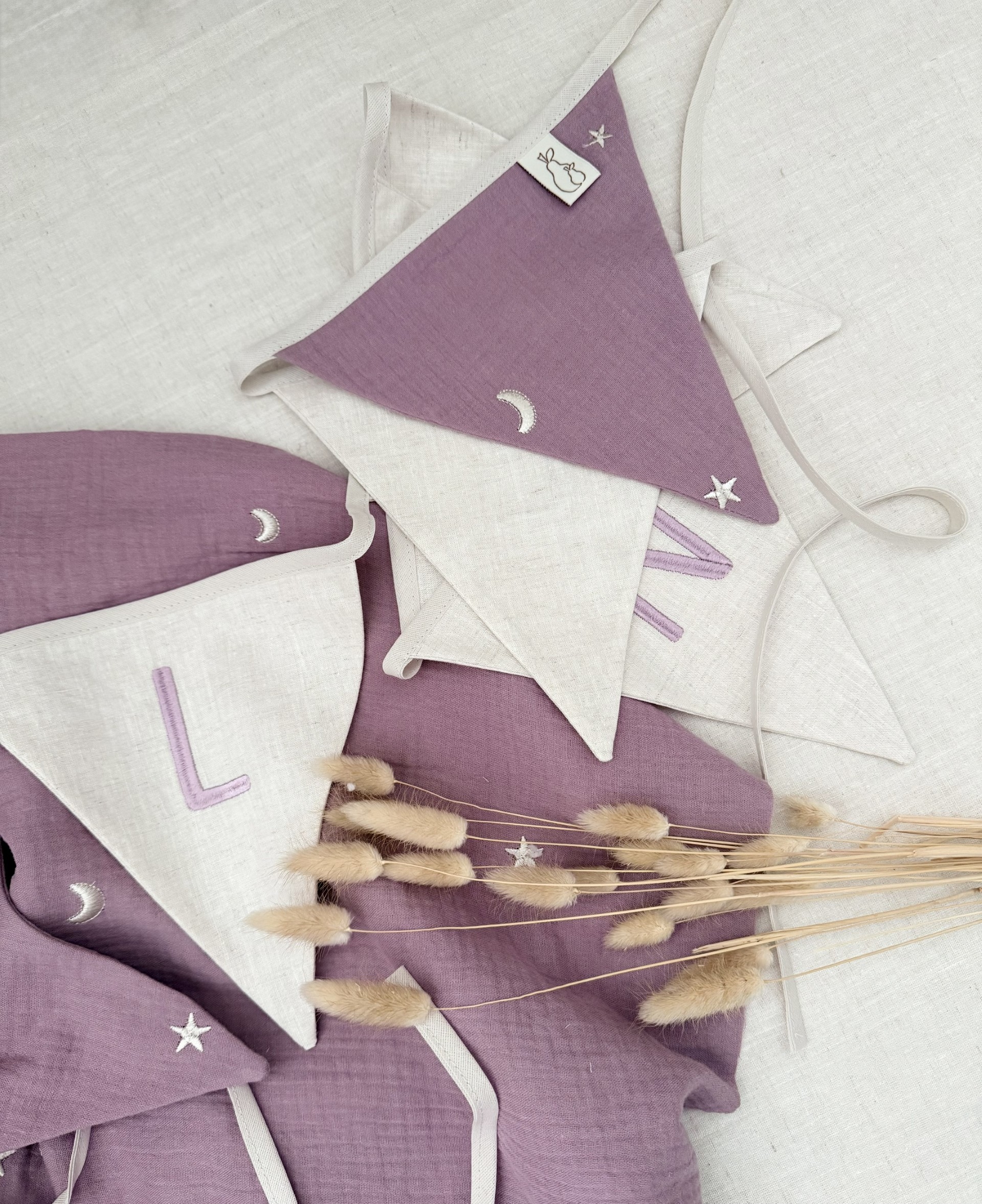een mooie naamslinger met driehoek vaantjes in mauve met gebrduurde letters.