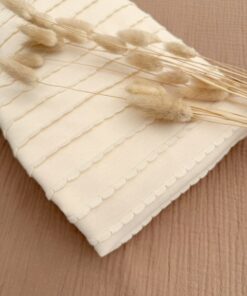 Omslagdoek en dekentje met streepjes en ruffles oftewel boogjes in een mooie ecru, lichtbeige kleur. De omslagdoek is gevoerd met bamboe teddy en lekker zacht.